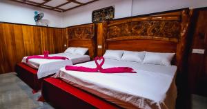 two beds with pink towels on them in a room at Maika safari lodge in Udawalawe