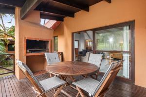 a wooden table and chairs on a deck with a fireplace at San Lameer Villa 2707 - 3 Bedroom Classic - 6 pax - San Lameer Rental Agency in Southbroom
