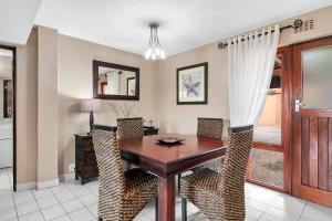 a dining room with a wooden table and chairs at San Lameer Villa 2826 - 2 Bedroom Classic - 4 pax - San Lameer Rental Agency in Southbroom