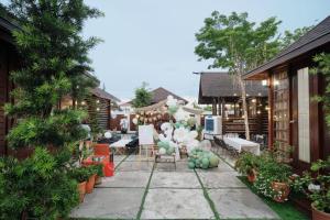 a patio with tables and chairs and plants at 巴厘岛风格住宿 Muar Balinese Resort in Muar