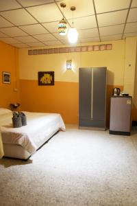 a large room with two beds and a refrigerator at Holiday Phangan - Hostel & Bar in Thongsala