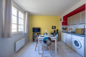 貝葉的住宿－Le gîte d'Isa，一间带桌椅的厨房和一间洗衣房