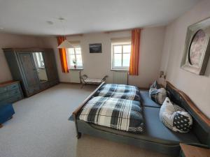 ein Schlafzimmer mit einem Bett mit einer Decke darauf in der Unterkunft Ferienwohnung Zittauer Gebirge in Waltersdorf