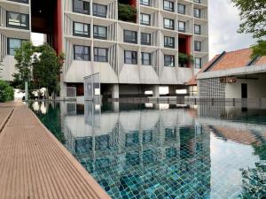 a building with a swimming pool in front of a building at Tamarind Suites by RD Heritage in Cyberjaya