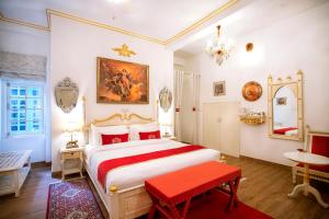 Un dormitorio con una gran cama blanca y un banco rojo en The Royal Hermitage - Best Luxury Boutique Hotel Jaipur en Jaipur