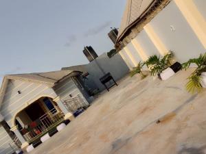 una grande casa con portico con palme di Meerah apartments & Hotels 