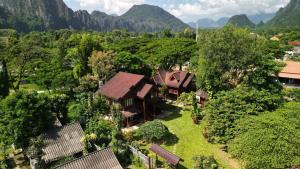 eine Luftansicht eines Hauses mit Bergen im Hintergrund in der Unterkunft Namsong Bridge Bungalows in Vang Vieng