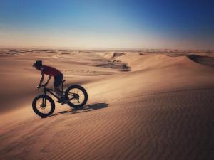 a person riding a bike in the desert at Cottage on Diamond Street in Swakopmund