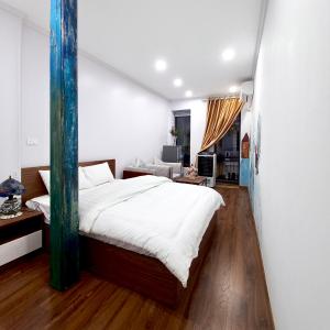 a bedroom with a large bed and a living room at Amelié Homestay in Hanoi