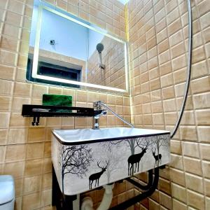 a bathroom sink with deer painted on it at Amelié Homestay in Hanoi