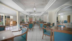 un comedor con mesas y sillas azules en Royal Brongto Hotel, en Timuran
