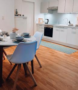 eine Küche mit einem Tisch und blauen Stühlen in einem Zimmer in der Unterkunft Suites in Mödling in Mödling