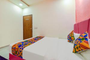 a bedroom with a bed with a colorful comforter at FabHotel Avadh Palace in Ahmedabad