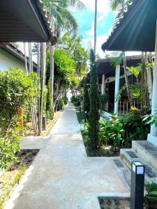 a walkway outside of a house with palm trees at Evergreen Resort in Chaweng