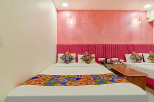 a bedroom with a bed and a red wall at FabHotel Avadh Palace in Ahmedabad