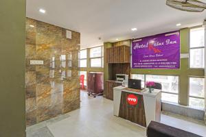 a lobby of a restaurant with a sign on the wall at Hotel Relax Inn in Gandhinagar