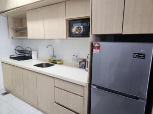 a kitchen with a refrigerator and a sink at SY@Tiara Homestay in Bangi