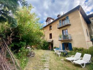 a house with white chairs in front of it at Grand studio classé 4 étoiles avec jardin et garage vélo, moto in Briançon