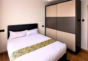 a bedroom with a large white bed and a cabinet at Urban Oasis Apartment by Edmor Suites in Nairobi