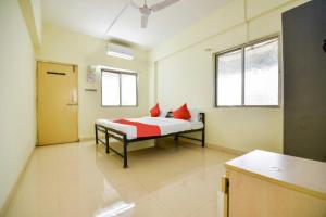 a room with a bed with red pillows in it at Hotel O Pratikruti Resort in Pune