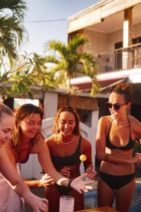 a group of women in bathing suits standing by a pool at Surf & Party - Hostel Somewhere Else in Canggu