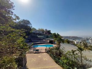 a swimming pool on top of a hill with a house at Hotel O Pratikruti Resort in Pune