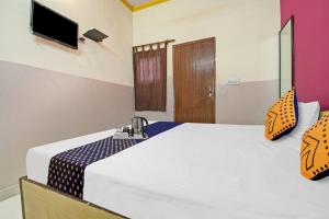 a bedroom with a large bed with a tv on the wall at Stephels Hostel in Jaipur