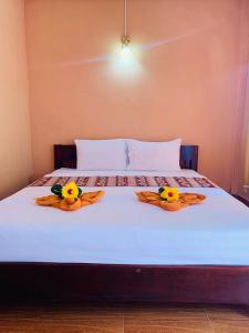 dos patos de goma están sentados en la parte superior de una cama en Inthila Garden Guest House en Vang Vieng