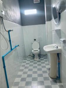 a bathroom with a toilet and a sink at Inthila Garden Guest House in Vang Vieng
