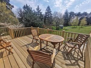 a wooden deck with a table and chairs on it at HAYNE BARN ESTATE - Froggies - Independent Self contained studio on private estate in Postling