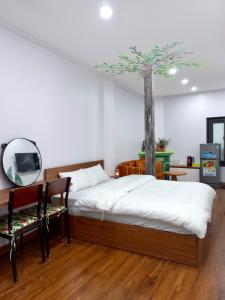 a bedroom with a bed with a tree on the wall at Amelié Homestay in Hanoi