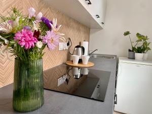 un jarrón de flores en un mostrador en una cocina en Studio Bielawa u podnóża Gór Sowich, en Bielawa