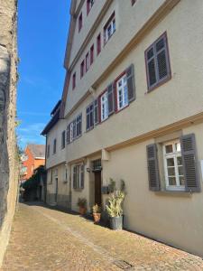 un edificio con ventanas en una calle adoquinada en Gästezimmer an der Stadtmauer en Besigheim