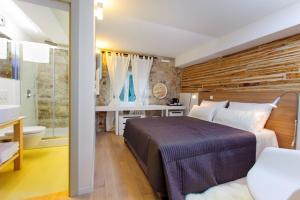 a bedroom with a large bed and a bathroom at Grgur Ninski Rooms in Split