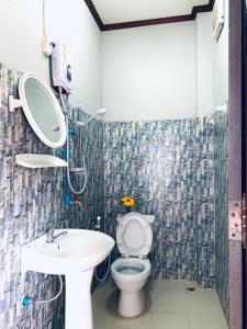 bagno con servizi igienici, lavandino e specchio di Inthila Garden Guest House a Vang Vieng