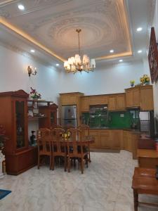 cocina con mesa, sillas y lámpara de araña en Linh's Home 101 Phòng riêng tiện nghi, en Tân Ðiền