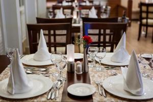 una mesa con platos blancos y servilletas. en Alba Queen Hotel, en Side