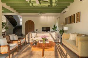 a living room with a couch and a table at La Mosteiro in Assagao, Splendid 3&4BHk Villas with Private Pool, Private Parking, Garden, Caretaker, Kitchen & Security in Vagator +216 photos