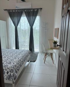 a bedroom with a bed and a desk and a window at House Of Nostalgia in Lumut