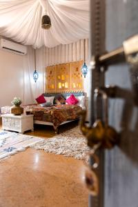 Casa De Kaku Jaisalmer في جيلسامر: غرفة نوم بسرير مع مظلة