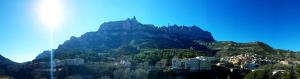 einen Berg mit Häusern und Gebäuden davor in der Unterkunft piso con desayuno incluido y vistas a la montaña. in Monistrol de Montserrat