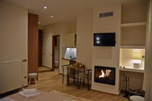 a living room with a fireplace and a table with chairs at Kleodora Apartments in Arachova