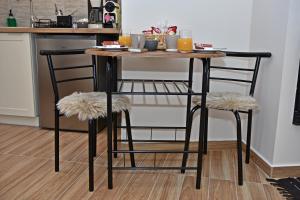 a kitchen table with two chairs and a table with drinks at Kleodora Apartments in Arachova