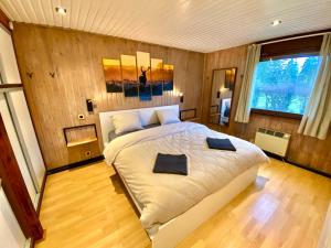 Au Chalet du Lac في بولانغ: غرفة نوم بسرير كبير في غرفة