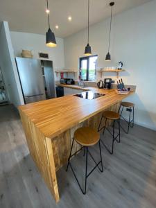 a kitchen with a large wooden counter with stools at Houseboat Islay in Bembridge