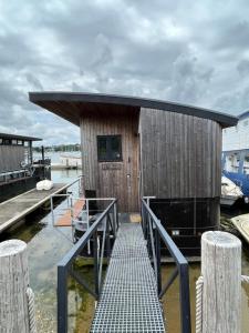 un pequeño edificio sobre el agua con muelle en Houseboat Islay en Bembridge