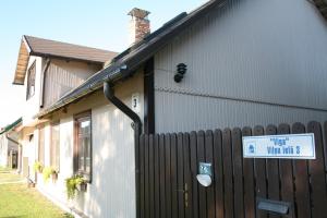 a building with a sign on the side of it at Guest House Viga in Pāvilosta