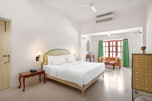 a white bedroom with a bed and a living room at Gaj Kesri by 7Apple Resorts in Bikaner +55 photos