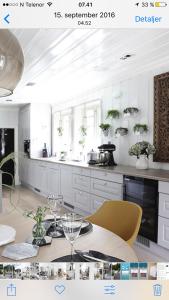 a kitchen with white cabinets and a table with yellow chairs at Villa Marikollen in Hektner