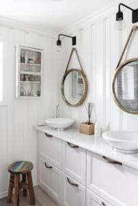 a bathroom with two sinks and two mirrors at Villa Marikollen in Hektner